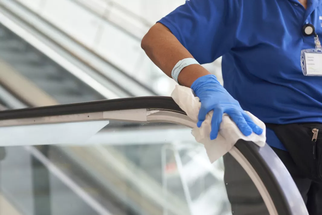 Man cleaning an escalator handle